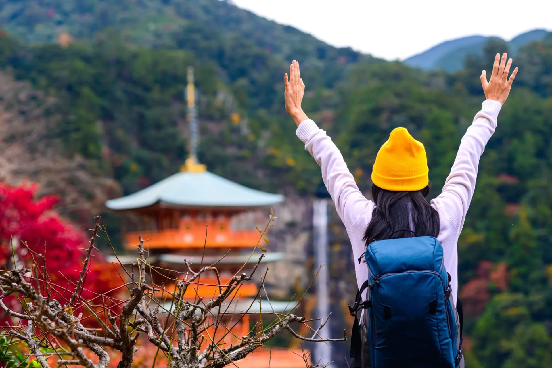 woman traveler tourist enjoy looking the wonderful shrine with waterfalls in background, Kumano Nashi Taisha, Nachi fall in Wakayama Prefecture a popular tourist place in Kyoto, Osaka, Japan