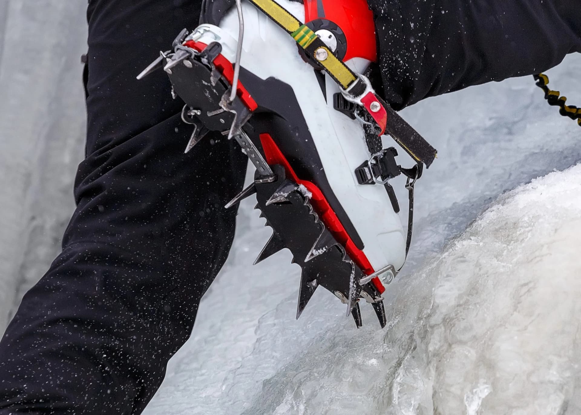 Climber on a frozen waterfall. Crampons close-up on his feet ice climber