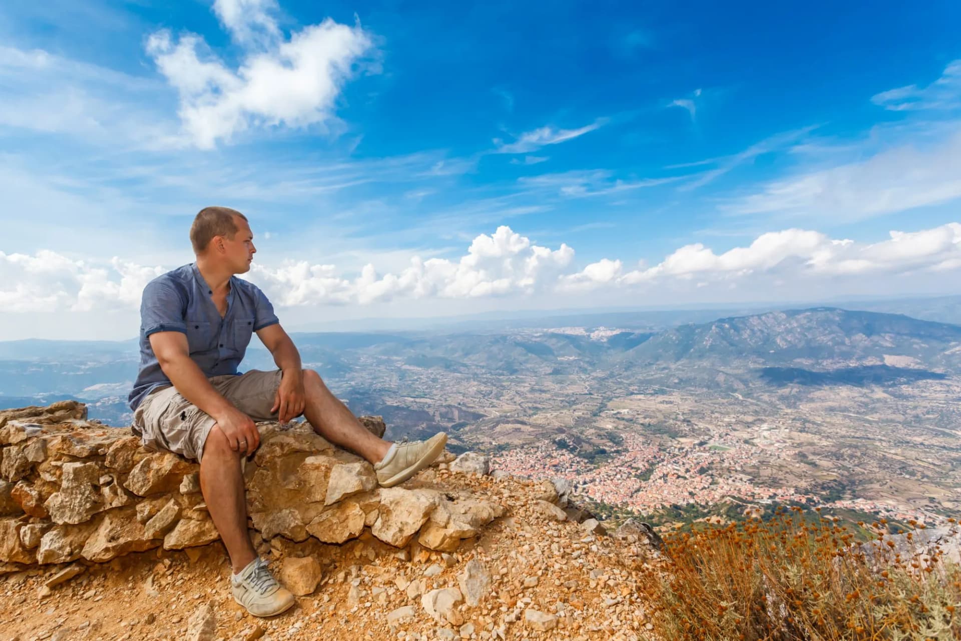 young man and panoramic view from the mountains