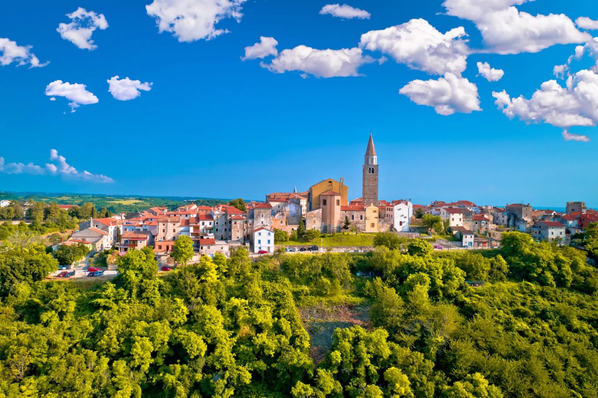 Old stone town of Buje on green hill aerial view