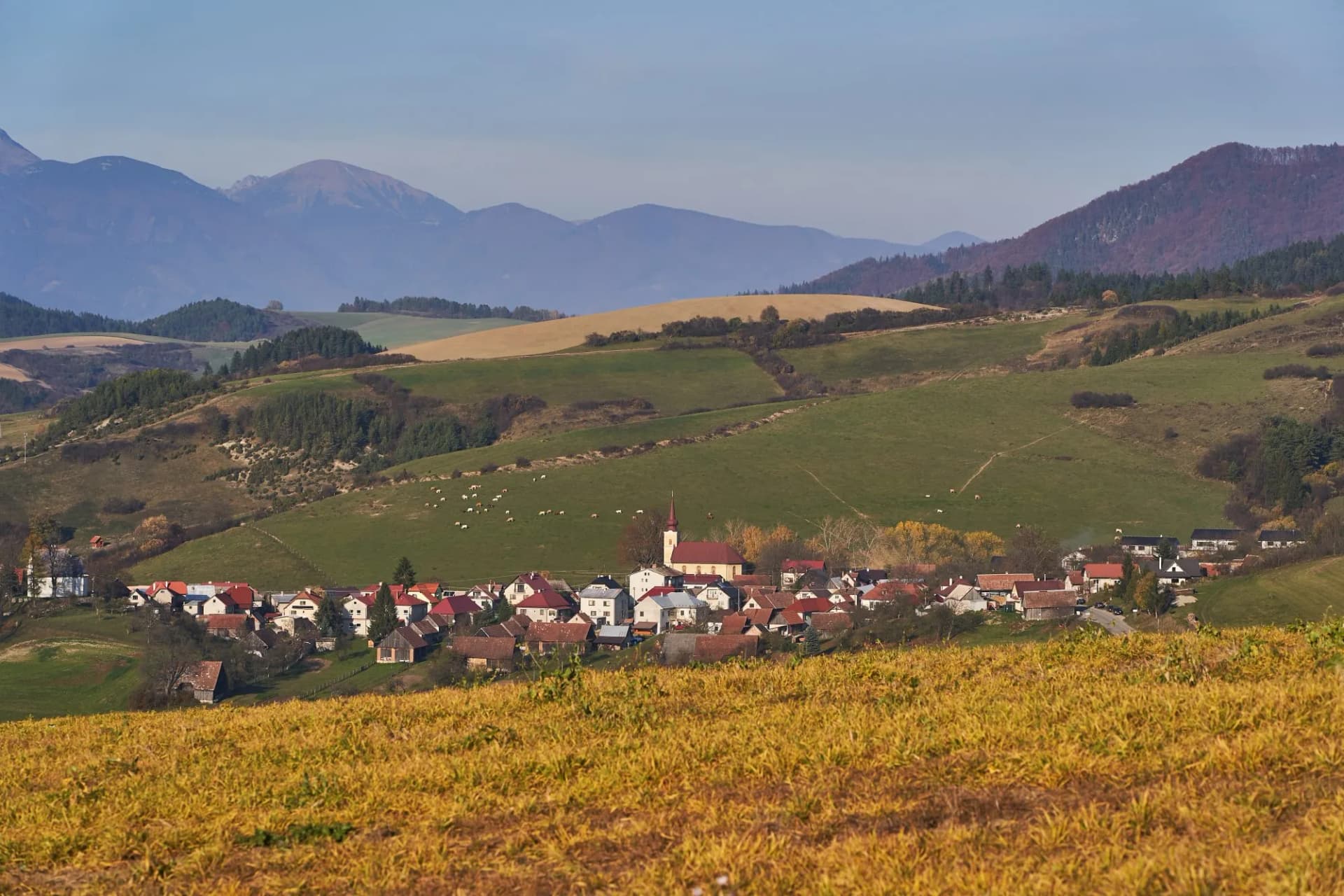 Landscape Picture of mountain countryside in Slovakia, europe in sunny autumn evening. Small village between fields and meadows of Mala and Velka Fatra mountain range in north west of Slovak Republic.